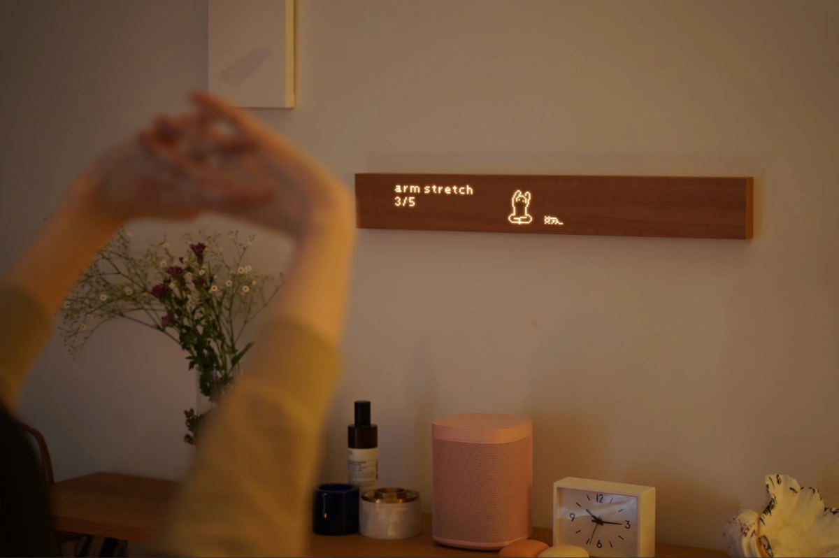 アームストレッチをしている様子と木製デジタルディスプレイ