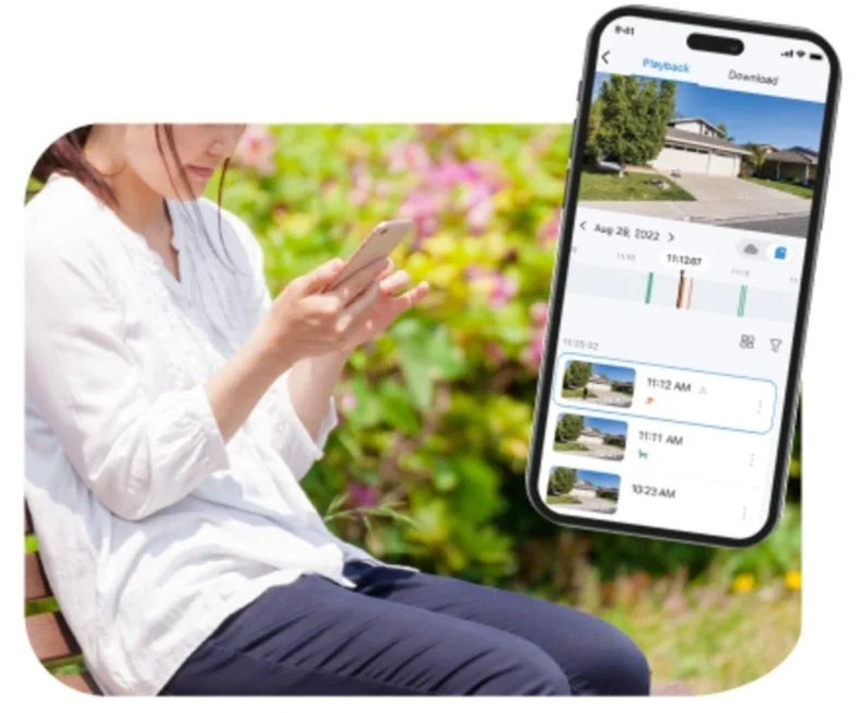 屋外でスマートフォンを操作し防犯カメラ映像を確認する女性