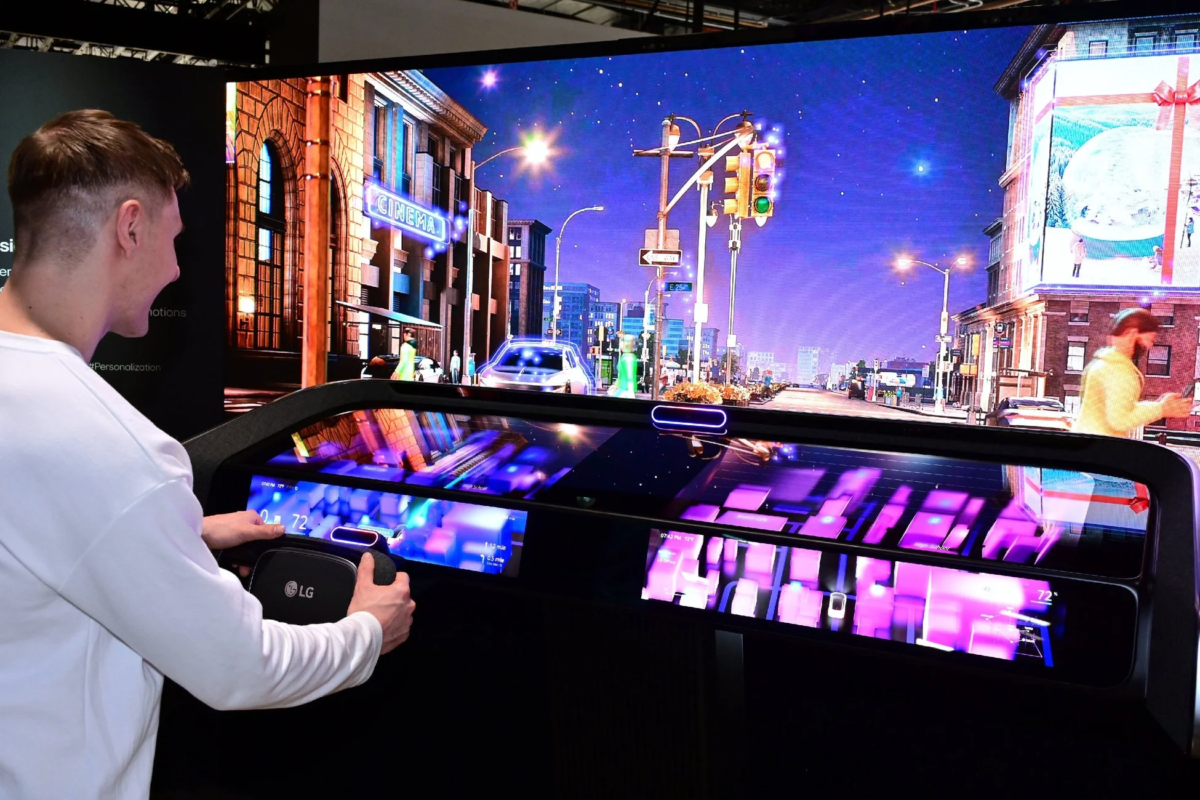 LG製のコントローラーを操作し、未来的なデジタルコックピットと大型ディスプレイで仮想都市の夜景を体験している様子