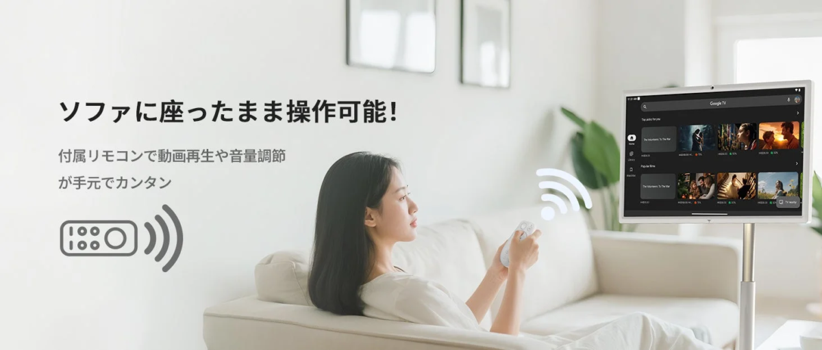 リビングルームのソファに座った女性が、付属のリモコンを使ってGoogle TVを操作している様子