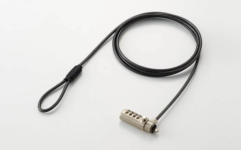 白い背景に置かれた、黒いセキュリティワイヤーとダイヤル式のロック機構のクローズアップ画像