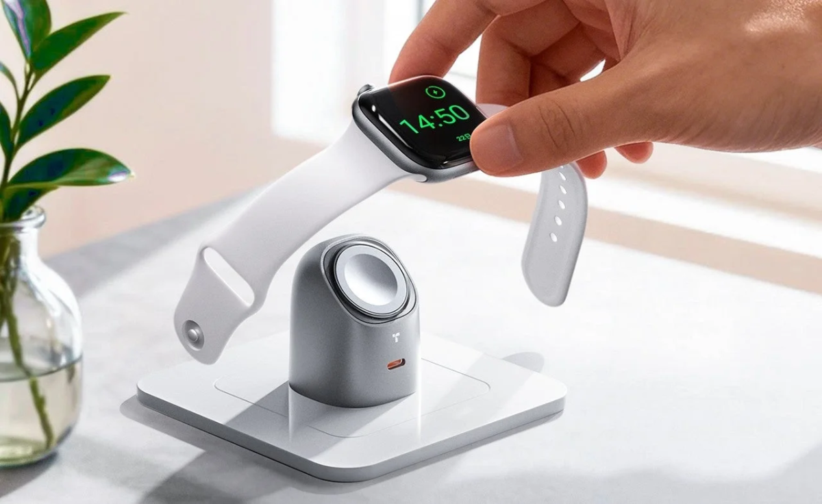 白いバンドのスマートウォッチを、手のひらで充電スタンドに置いている様子を捉えた画像です。時計の画面には「14:50」と表示されています。