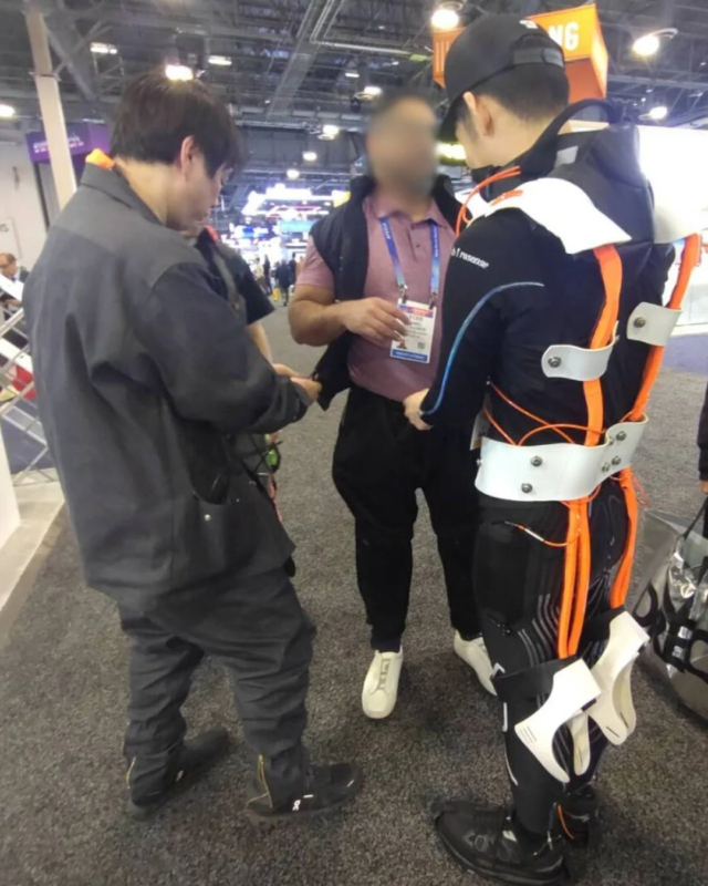 展示会でウェアラブルデバイスの説明を受ける来場者