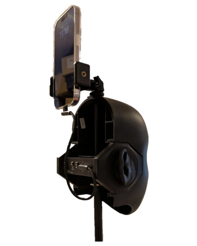 黒いダミーヘッド型デバイスがスタンドに取り付けられ、その上部にスマートフォンが固定されています。