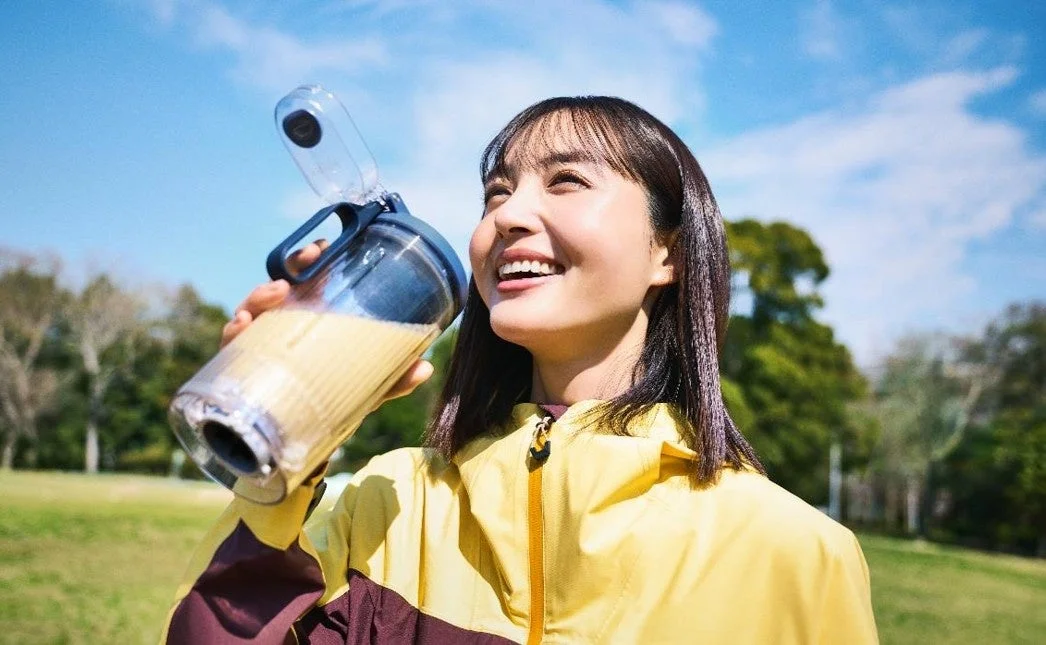 屋外でドリンクを飲む女性