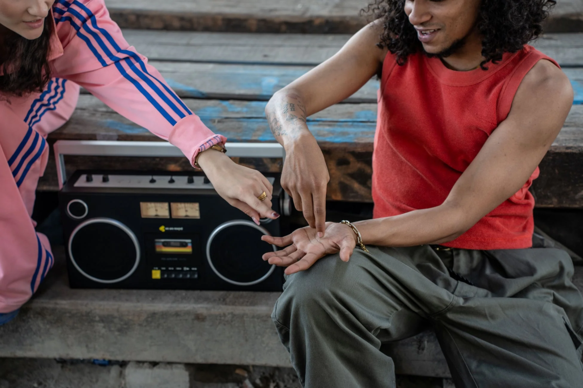 男女がブームボックスのそばで手を重ねる