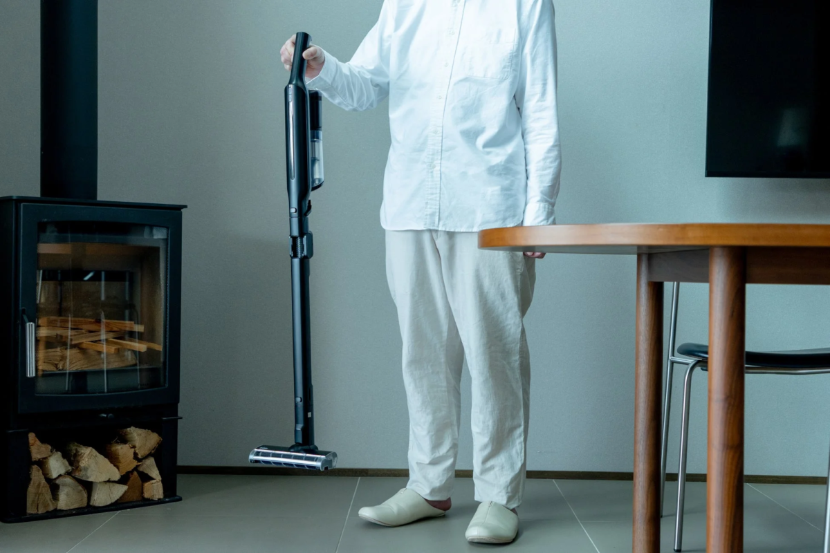 リビングで掃除機を持つ人