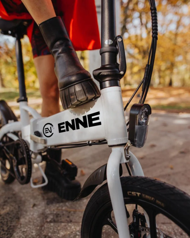 白い折りたたみ電動自転車に乗る人物の足元