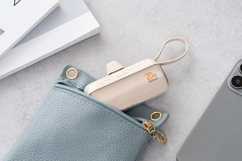 青いポーチから出ているクリーム色の小型モバイルバッテリーが写っています