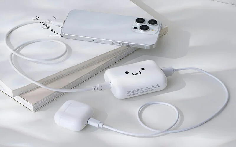 スマートフォンとワイヤレスイヤホンを充電中のモバイルバッテリー