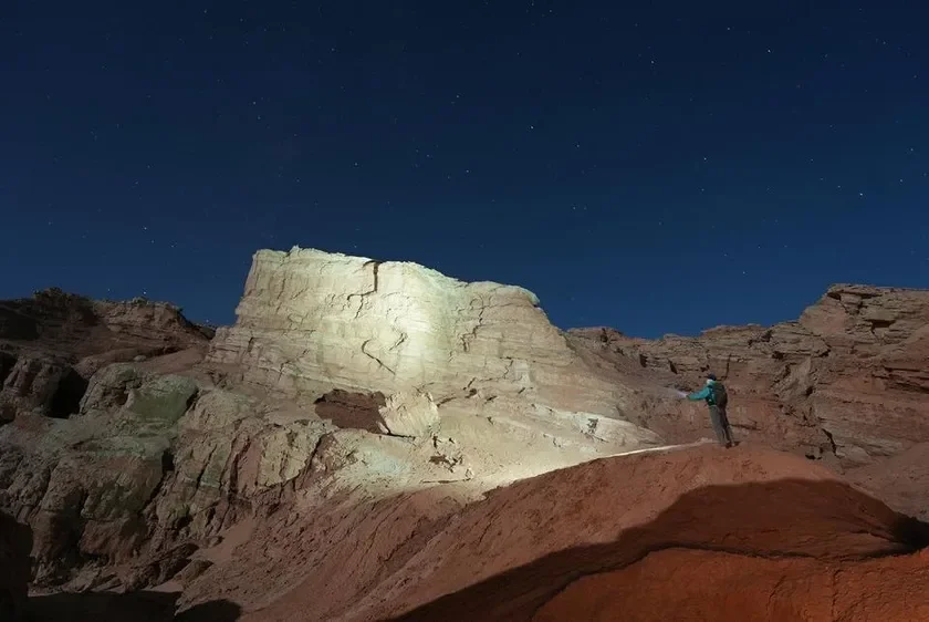 夜の砂漠を照らす懐中電灯