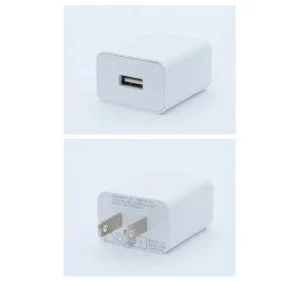 白いUSB充電器を異なる角度から撮影した画像です。上部にはUSB-Aポート、下部には2ピンのコンセントプラグが見え、製品情報も一部読み取れます。
