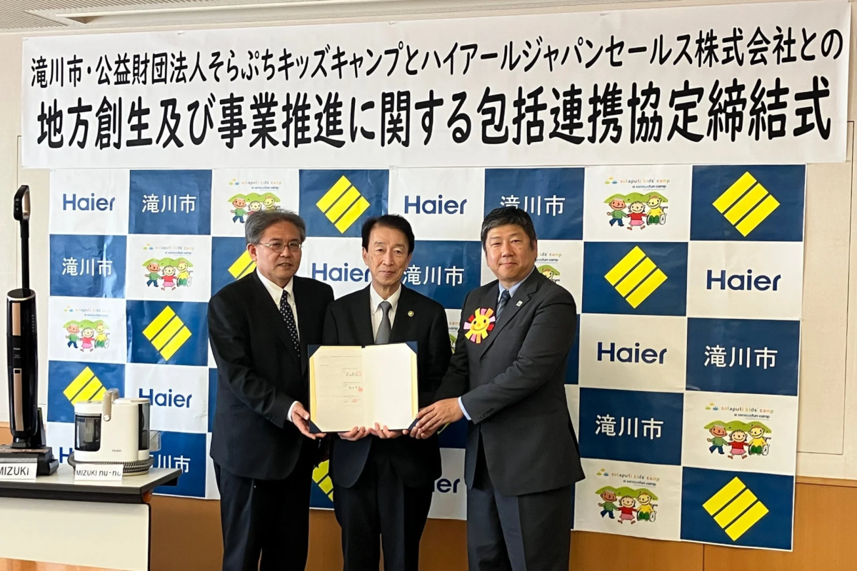 協定書を手に記念撮影をする関係者