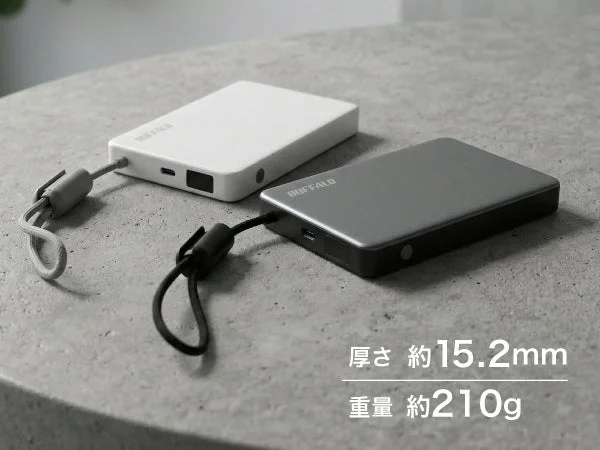 BUFFALO製の白とダークグレーのポータブルSSDが2台並べられています。それぞれストラップが付属しており、厚さ約15.2mm、重量約210gと、薄型軽量で持ち運びやすいデザインが特徴です。