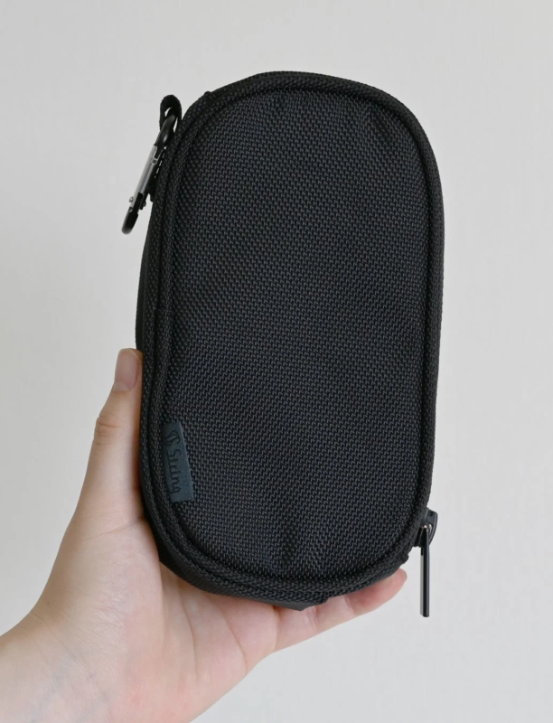 「Suding」のロゴが入った黒いシンプルなポーチを手のひらで持っている画像。