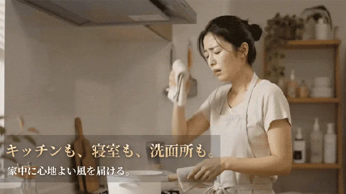 キッチンで汗を拭う女性