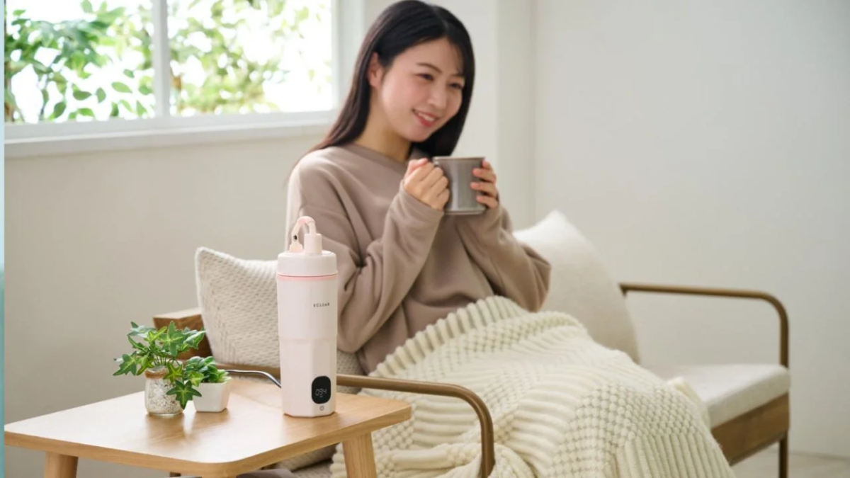 窓辺でリラックスする女性とポータブルケトル
