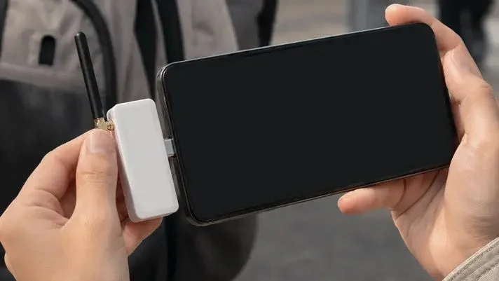 スマートフォンに外部デバイスを接続している人物